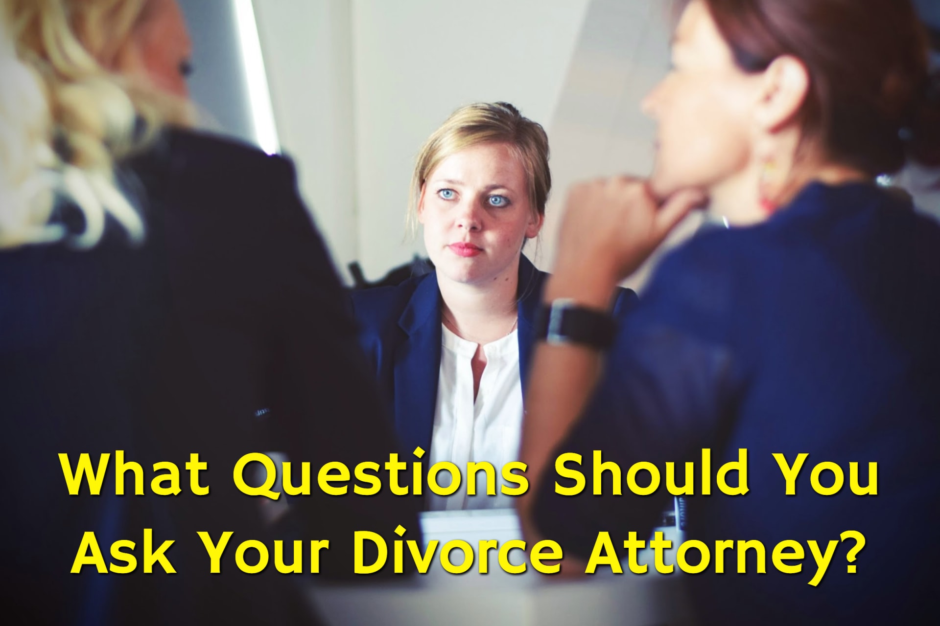A woman consulting with her attorneys and contemplating which questions to ask a divorce attorney